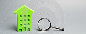 Miniature wooden house and magnifying glass. Home appraisal. Property valuation. House searching concept. Choice of location for