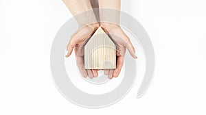 Miniature wooden house model. Home insurance and protection. Construction buying a home loan. In hand on a white background.