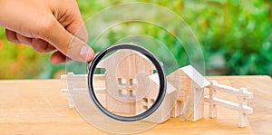 Miniature wooden houses and a fence on a green bokeh background.