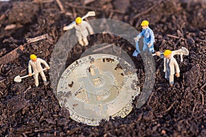 Miniature worker people found gold bitcoin in soil agricultural