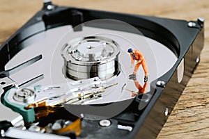 Miniature worker or professional staff digging on HDD, hard drive using as data mining, data restore or fixing and repair computer