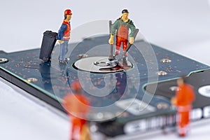 Miniature Workers cleaning a broken hard drive and recycle it