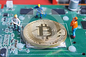 Miniature working man digging and mining Bitcoin on printed circuit board