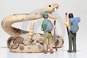 Miniatures of hikers in front of a giant rattlesnake