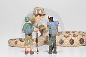 Miniatures of hikers in front of a giant rattlesnake
