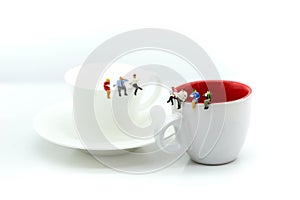 Miniatures people : sitting on a cup of coffee,relax and business concept.