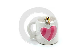 Miniatures people : sitting on a cup of coffee,relax and business concept.