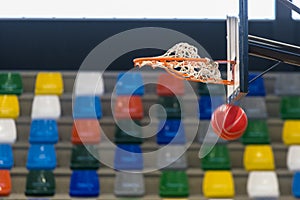 A red ball goes through a basketball basket photo