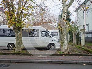 Minibuses at the old house. Yard in Batumi. Parked vehicles photo