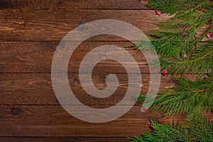 Minimal christmas composition. Cypress branches and small red stars, on dark wooden background