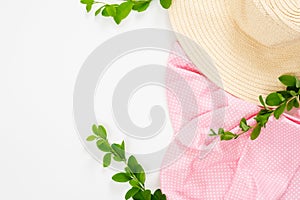 Minimal composition with straw hat, pink cloth and branch of barberry on white background. Flat lay, top view. Summer vacation