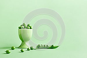 Minimal food creative concept. Fresh green peas on light green pastel background.