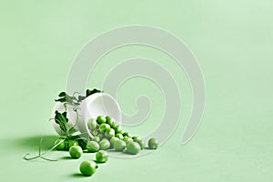 Minimal food creative concept. Fresh green peas on light green pastel background.