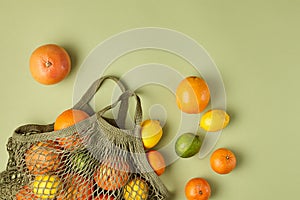 Minimal fruit and reusable background. Citrus with reusable bag over green background. SImple eco top view