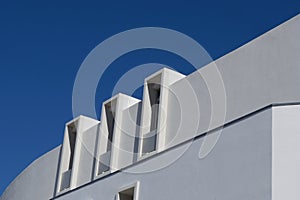 Minimal lines of modern white building against saturated blue sky. Lined minimalistic architecture