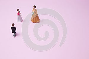 Minimal marriage proposal scene with figurines, on a pink background with copy space