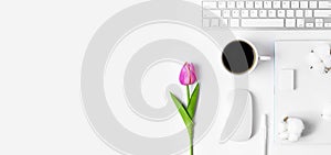 Minimal Office desk table with Keyboard computer, coffee cup, mouse, white pen, cotton flowers, tulip flowers, eraser on a white