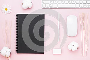 Minimal Office desk table with Keyboard computer, mouse, white pen, cotton flowers, eraser on a pink pastel table with copy space