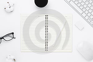 Minimal Office desk table top view with open notebook blank pages, Keyboard computer, mouse, coffee cup on a white table with copy