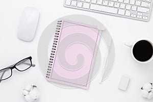 Minimal Office desk table top view with pink notebook blank pages, Keyboard computer, mouse, coffee cup on a white table with copy