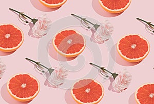 Minimal romatic pattern made with pink flowers and grapefruit on pastel background. Creative spring romance composition