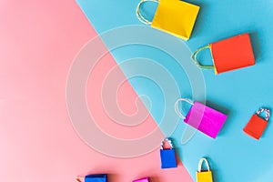 Minimal shopping online concept, Colorful paper shopping bag go down from floating pink and blue background for copy space