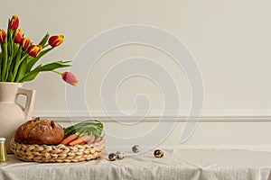 Minimal spring composition of easter living room interior with copy space, beige vase with tulips, braided basket with carrot,