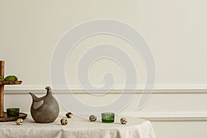 Minimal spring composition of easter living room interior with copy space, beige wall with stucco hen sculpture, green glass,