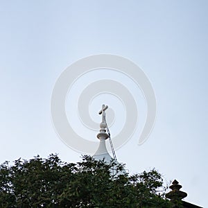 Minimal view over the top of a church at the end of the day, white cross in blue sky, Madeira, Portugal photo