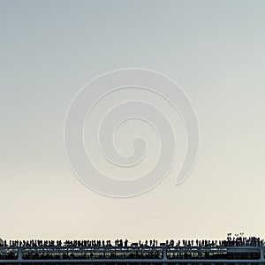 Minimal square view over the top of liner uper desk in backlight, several silhouettes and sunset light.