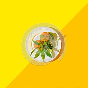 Minimal style composition made of fresh orange tangerines on a plate. Summer refreshment concept. Top view. Flat lay