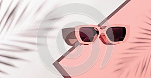 Minimal style composition made of sunglasses on pastel peach and white sunlit background with palm tree leaf shadow