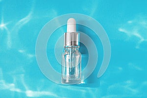 Minimal style composition made of transparent glass serum bottle with pipette with collagen or hyaluronic acid or essential oil on