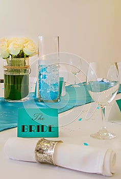 Minimal wedding arrangement for the bride`s table in turquoise blue and white