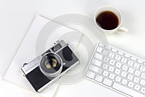 Minimal white work space with vintage style camera
