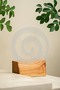 Minimal wood podium with blurred green leaf plant on beige background.Beauty cosmetic natural mild product modern display,nature