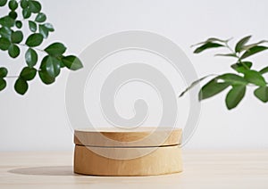 Minimal wood podium table top blurred green leaf plant on white space nature background.Beauty cosmetic natural product display