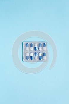 Minimalism. Packaging of blue capsules with medicine, on a blue background. Painkiller. Medicine concept. Copy space.