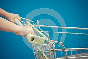 Minimalism style, Shopping cart and blue wall and human hand.