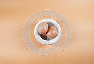 Minimalist abstract modern composition of Easter eggs on orange background and a white bowl