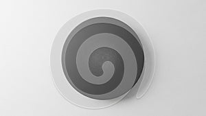 Minimalist black circular object with subtle spiral texture on white background