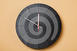 Minimalist black wall clocks on brown background