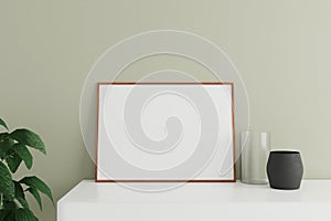Minimalist and clean horizontal wooden poster or photo frame mockup on the white table leaning against the room wall with vase and