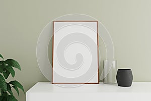 Minimalist and clean vertical wooden poster or photo frame mockup on the white table leaning against the room wall with vase and