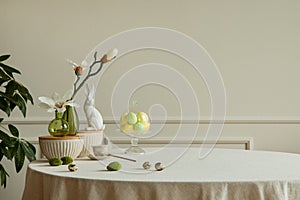 Minimalist composition of easter dining room interior with copy space, gray easter bunny sculpture, colorful eggs, vase with