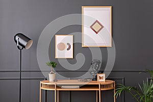 Minimalist composition of living room interior with mock up poster frame, wooden desk, books, lamp, sculpture, vase with dried