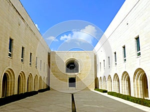 Minimalist courtyard design of a public building with arches and windows