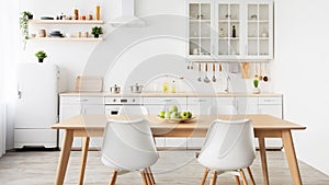 Minimalist design of kitchen. Plate of apples on table, kitchenware and utensils on furniture, panorama