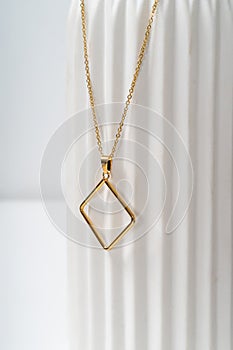 Minimalist Gold Necklace on Textured White Background photo