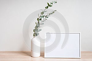 Minimalist home decor with empty frame mock-up on white wall background